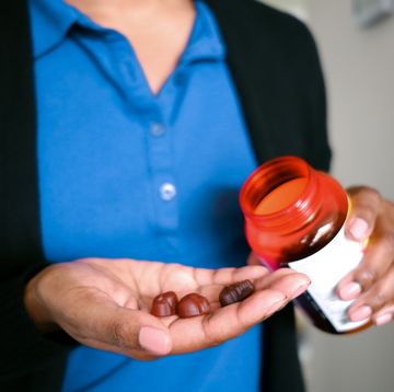 woman holds fruit flavored multivitamins