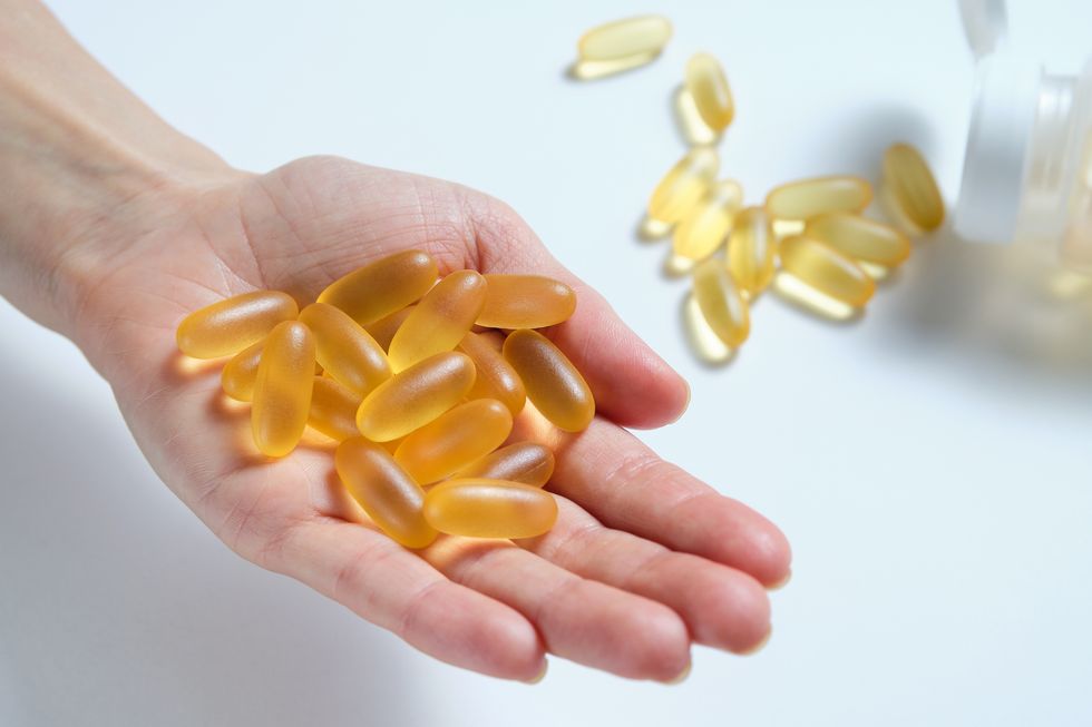 a woman holds omega 3 fish oil capsules in the palm of her hand or in her hand healthy lifestyle, prevention and treatment of diseases the girl takes and drinks dietary supplements and vitamins biologically active additive intake of healthy fats