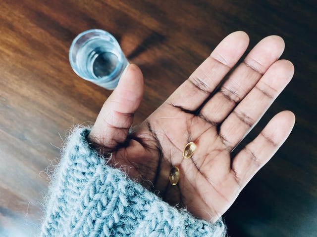 woman holds vitamin d supplements