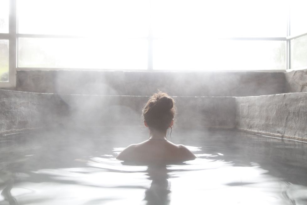 Woman in an outdoor bath with steam