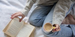 woman in bed with coffee and book