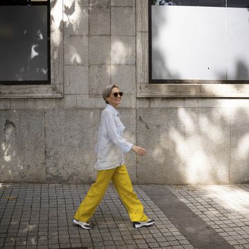 woman in casuals walking on sidewalk