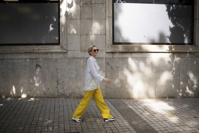 woman in casuals walking on sidewalk