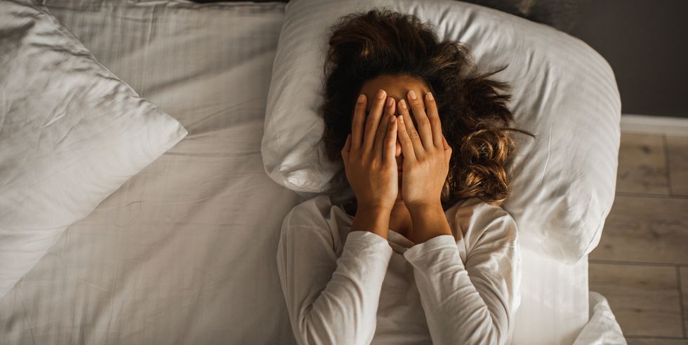 woman in depression closed face with hands and crying in bed melancholy mood, mental health life problems