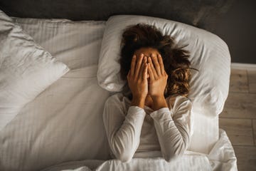 woman in depression closed face with hands and crying in bed melancholy mood, mental health life problems