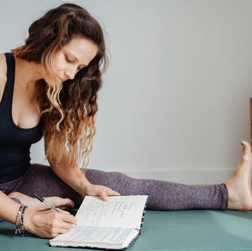 Woman in exercise clothes writing in a journal notebook woman in exercise clothes writing in a journal notebook