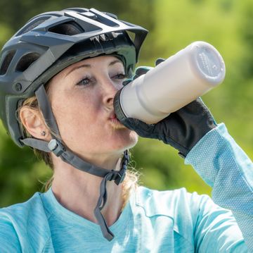 woman in helmet drinking water