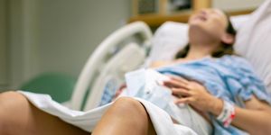 a woman in labor, with painful contractions, lying in the hospital bed childbirth and baby delivery