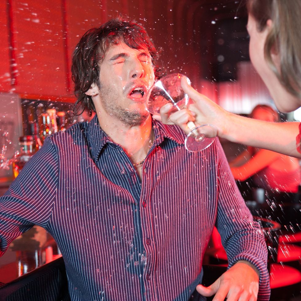 woman in nightclub throwing beverage in man's face