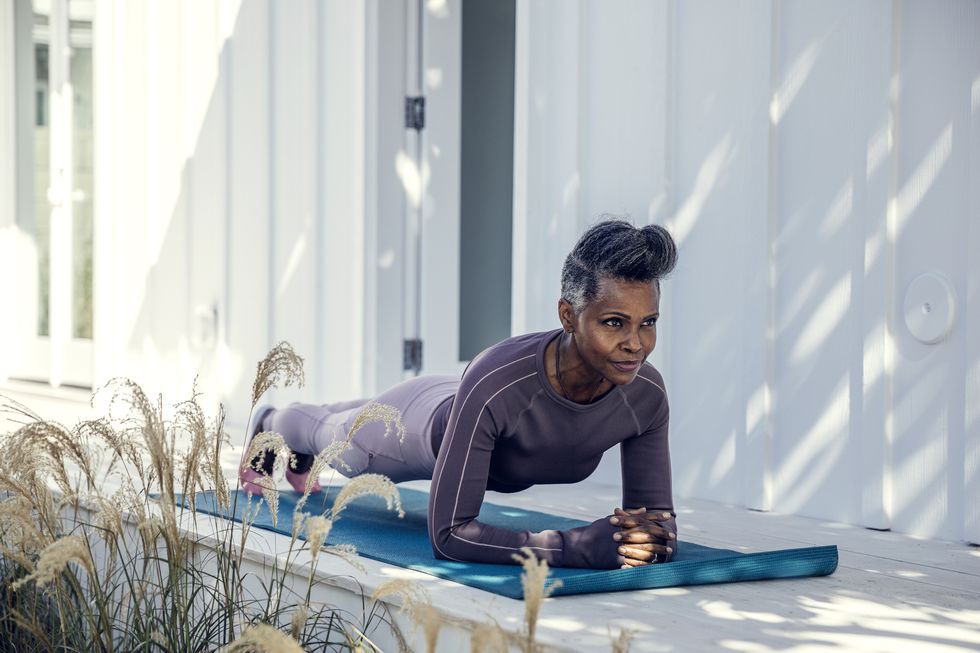 woman in plank position on exercise mat