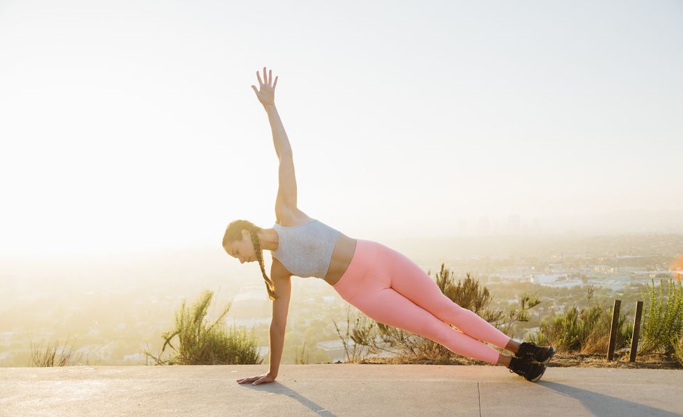Woman in plank position on hilltop