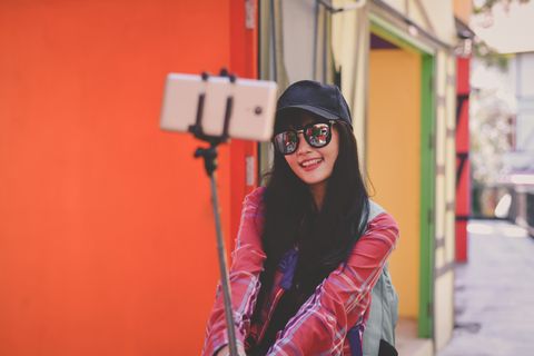 Woman In Sunglasses Taking Selfie Through Mobile Phone