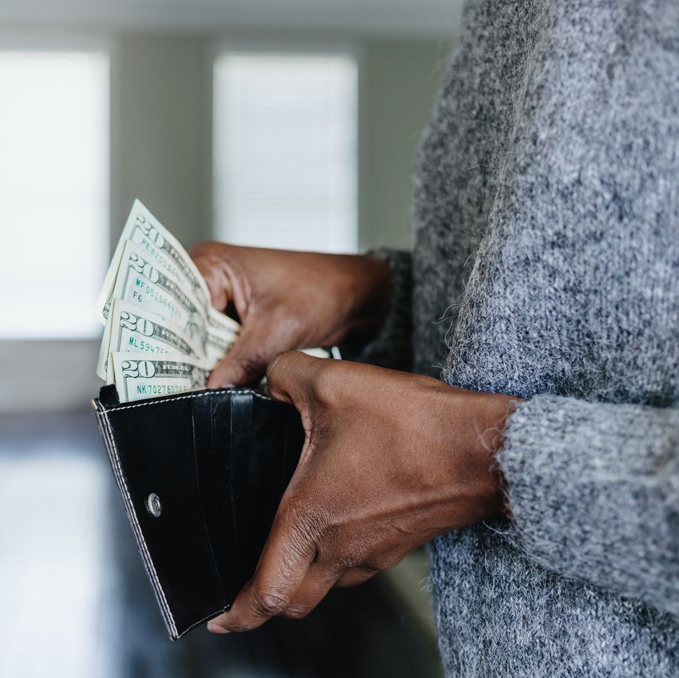 woman inserts cash into wallet