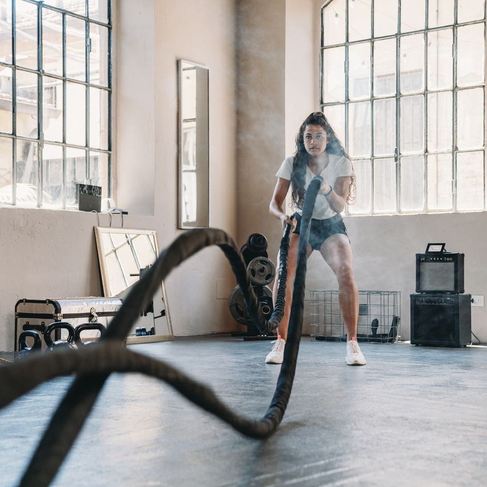 a woman is doing exercises with a rope at the gym