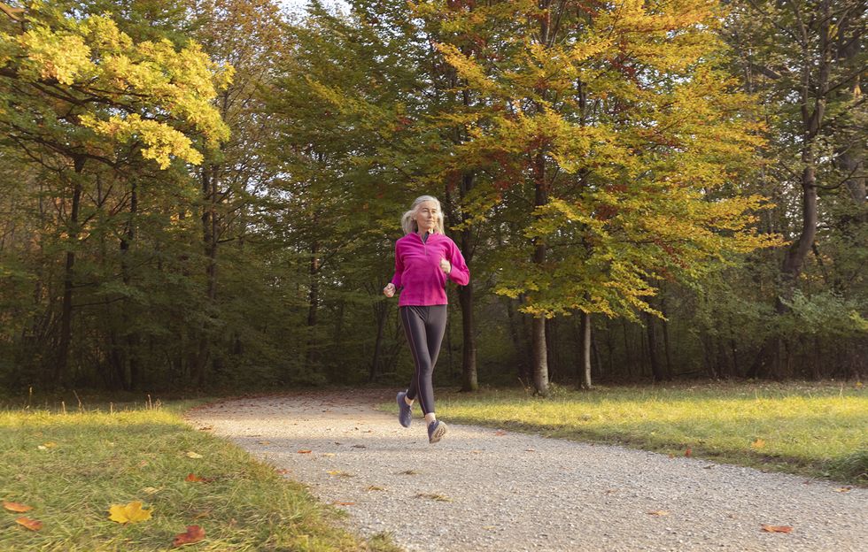 woman jogging in park against trees