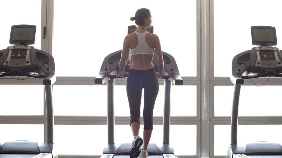 ragazza che cammina sul tapis roulant in palestra