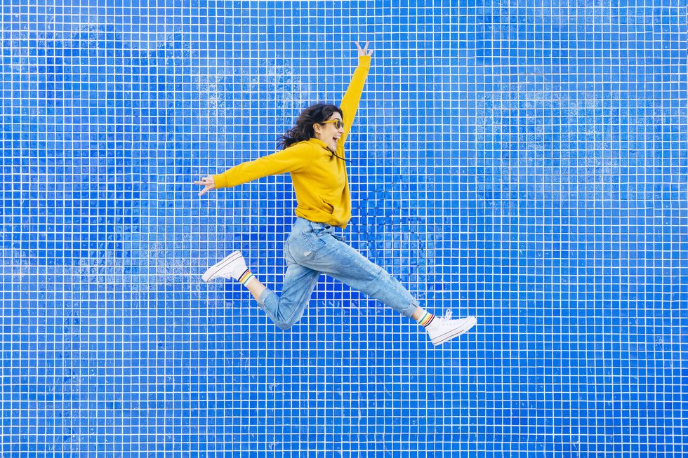 woman jumping in front of a blue background