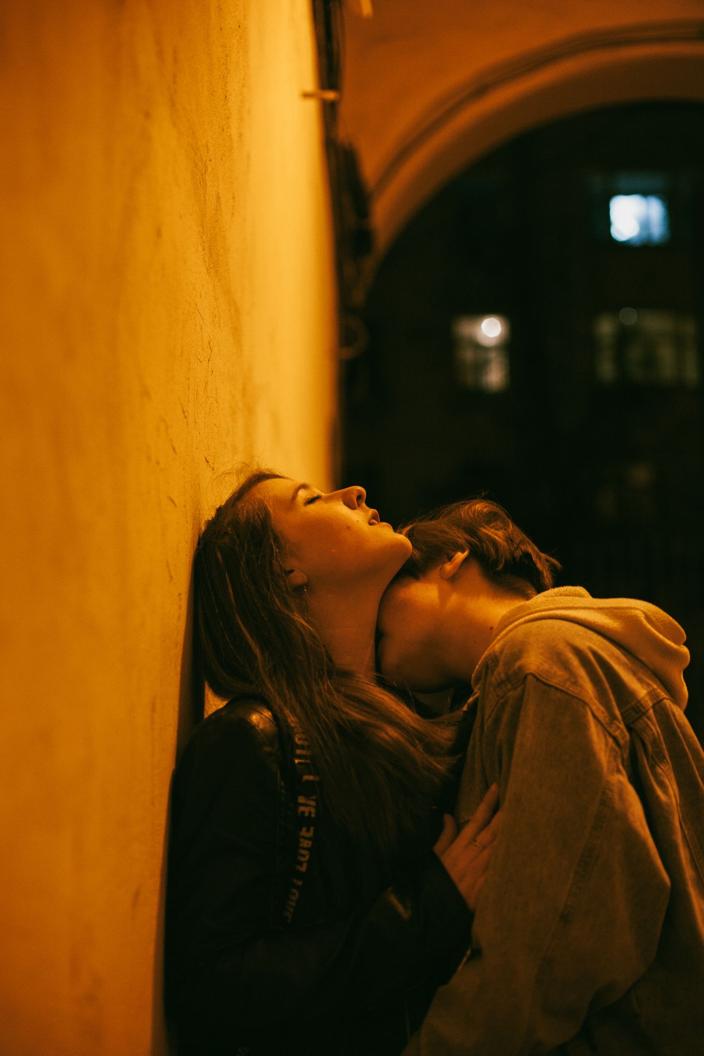 woman kissing girlfriend in city during night