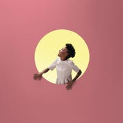 Woman laughing, placed inside round opening in coloured wall woman laughing, placed inside round opening in coloured wall