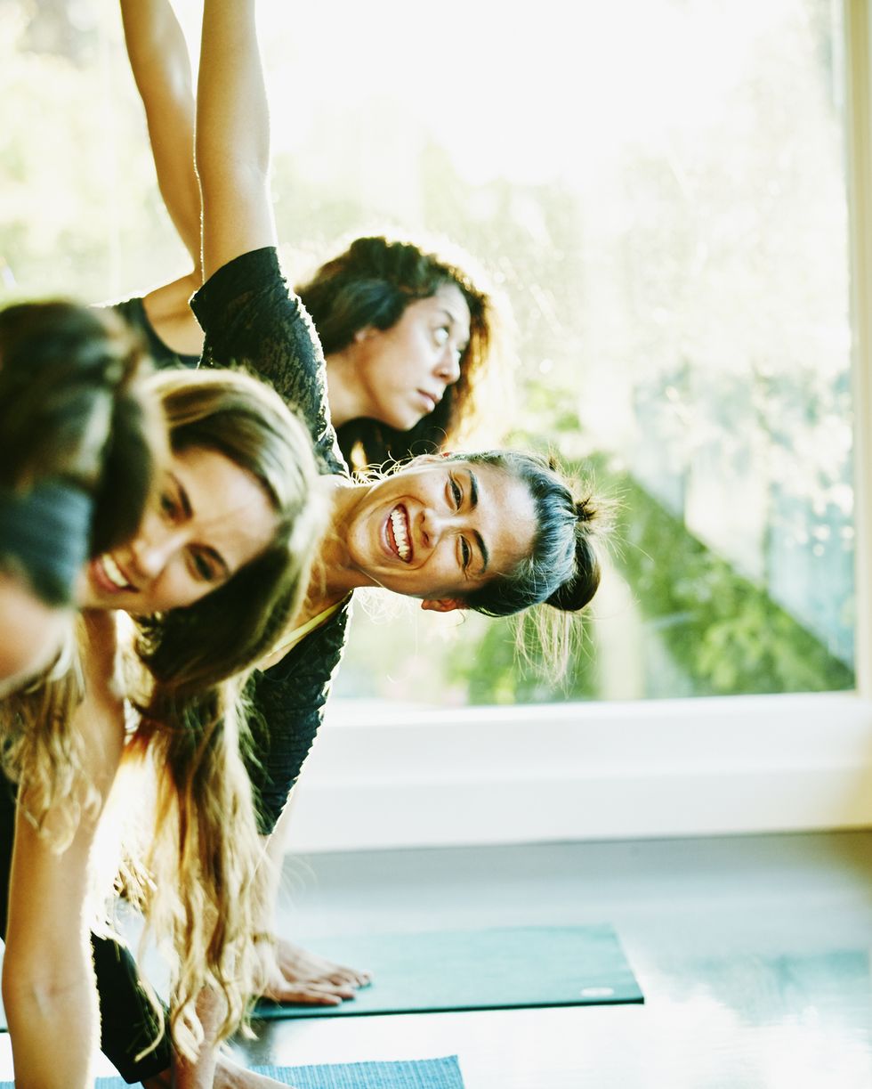 Woman laughing with friends during yoga class
