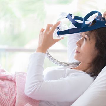 woman lay in bed wearing cpap mask ,sleep apnea therapy