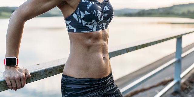 Woman leaning on railing showing abdominal muscles