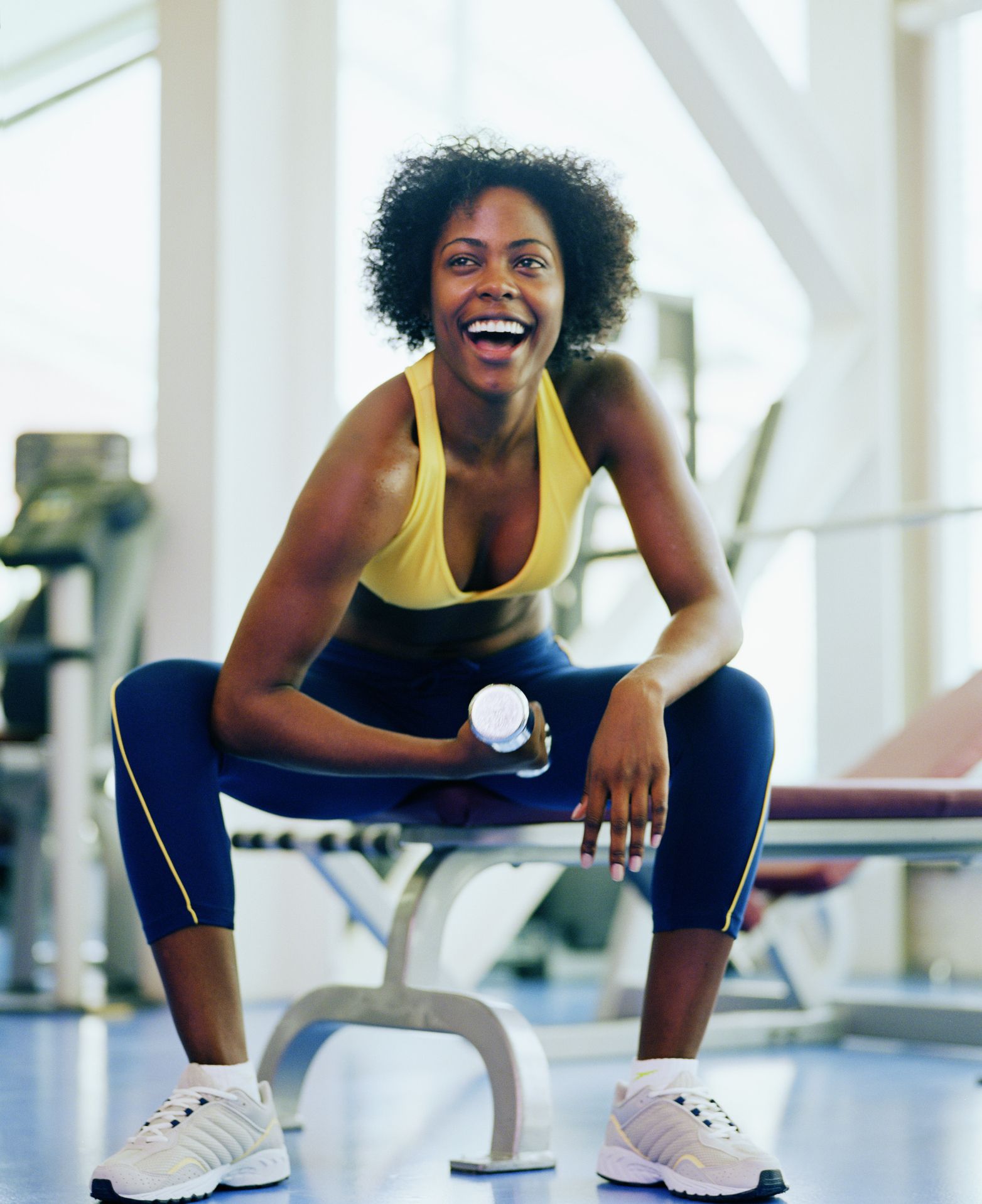 https://hips.hearstapps.com/hmg-prod/images/woman-lifting-dumbbell-in-gym-smiling-close-up-royalty-free-image-1652903489.jpg