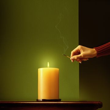 woman lighting candle with match