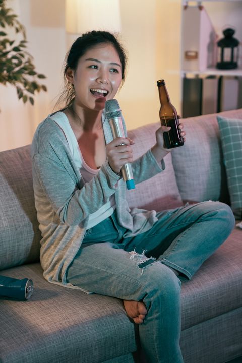 woman listening music singing drinking beer