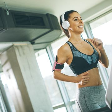 woman listening to music while exercising at gym