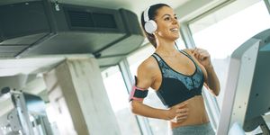 woman listening to music while exercising at gym