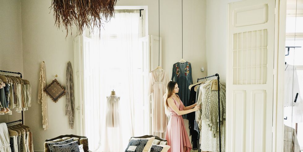 woman looking at dresses while shopping in boutique