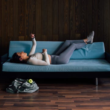 vrouw ligt moe op de bank na training