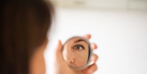 woman looking at herself in the mirror close up shot