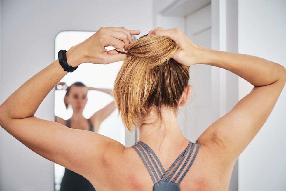 woman looking at mirror after home fitness exercise