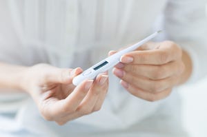 woman looking at thermometer