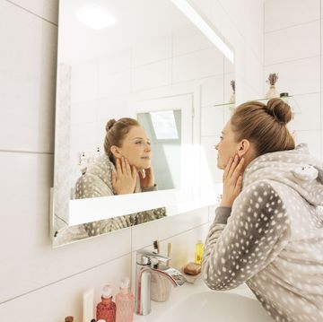 woman looking in mirror at home