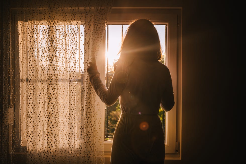 woman looking through window