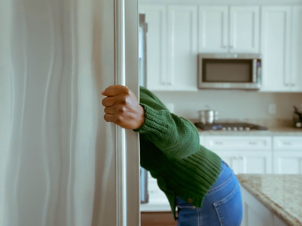 woman looks into refrigerator for healthy snack
