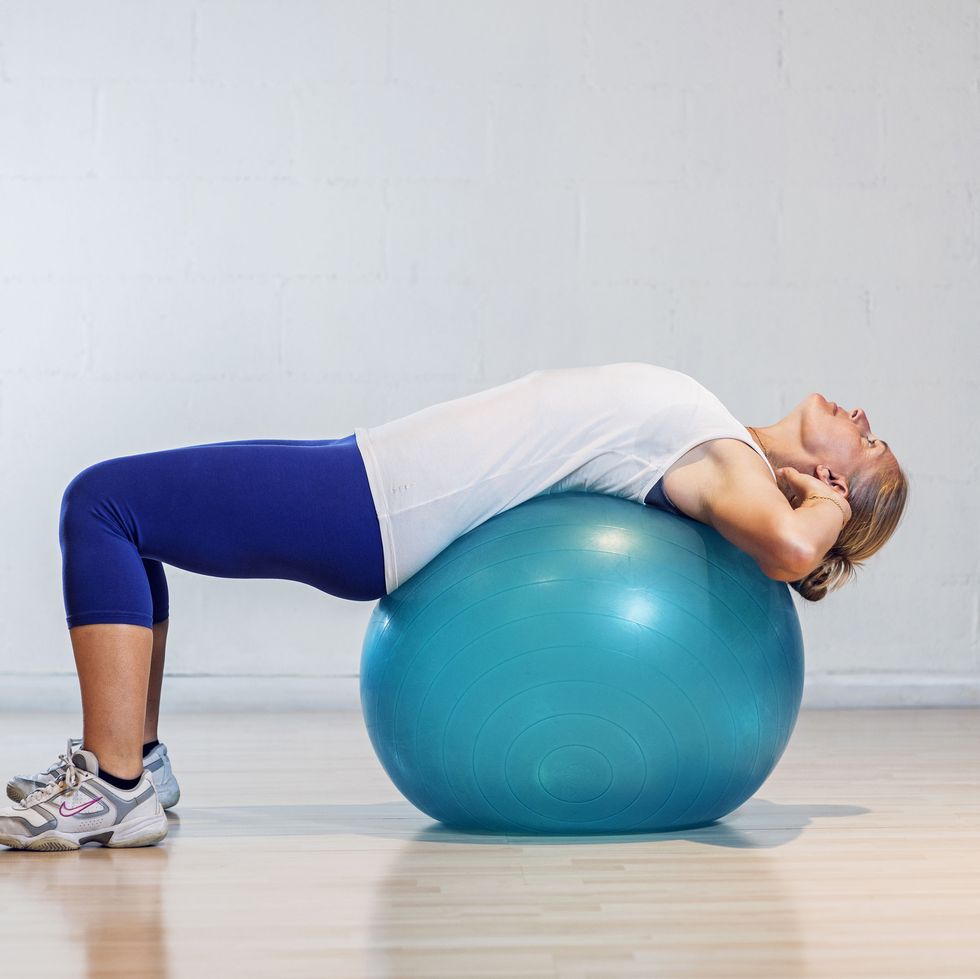 Woman lying down on a fitball