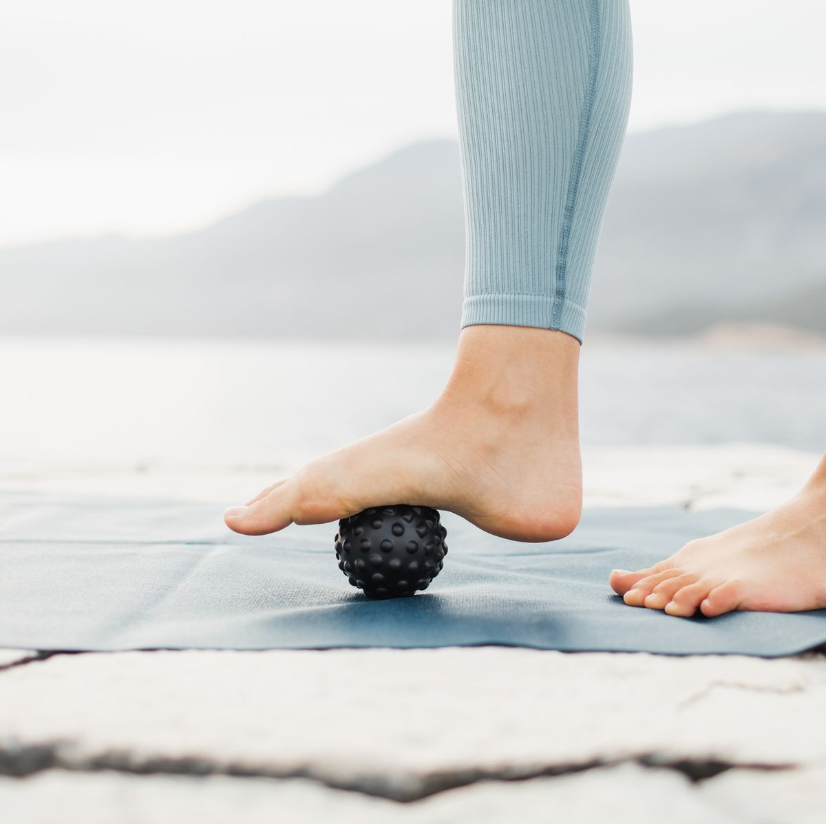 https://hips.hearstapps.com/hmg-prod/images/woman-massaging-foot-with-black-massage-ball-roller-royalty-free-image-1663853521.jpg?crop=0.668xw:1.00xh;0.167xw,0&resize=1200:*