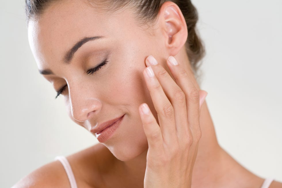 woman massaging her face with finger