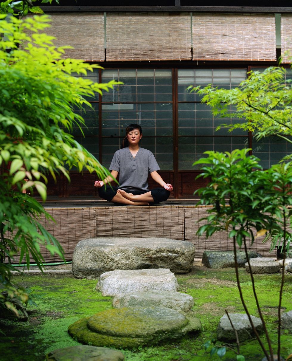 woman meditating in temple garden