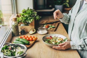 vrouw maakt salade met veel groenten