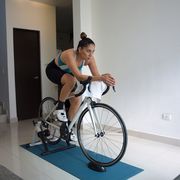woman riding indoors on a bike trainer