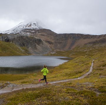 a woman on a trail run through a scenic area near banff