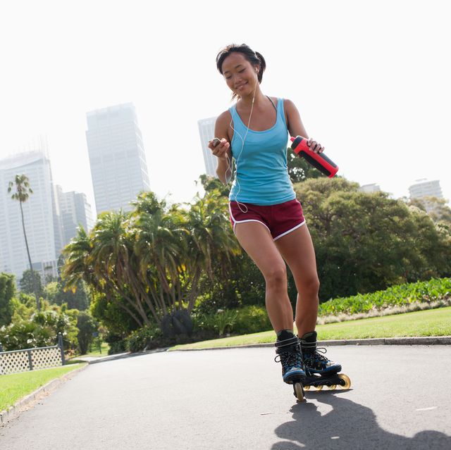 woman on inline skates looking at mp3 player