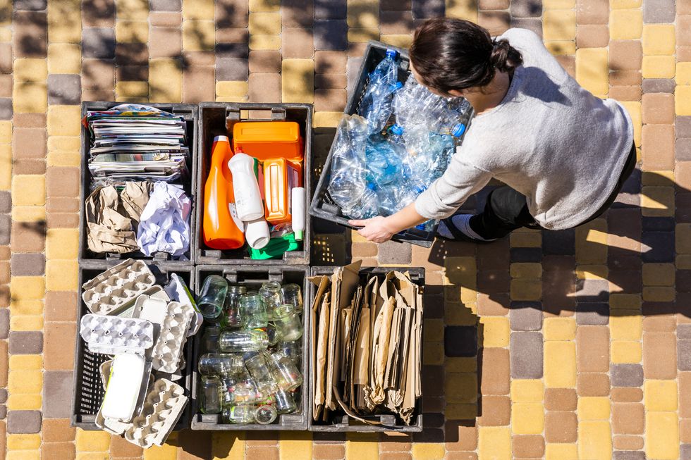 woman organizes garbage containers for recycling