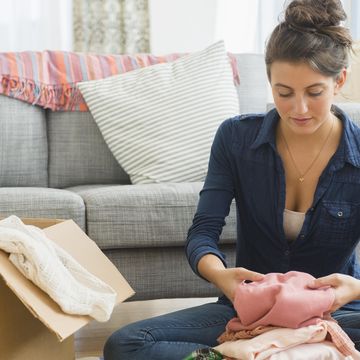 woman packing clothes to box