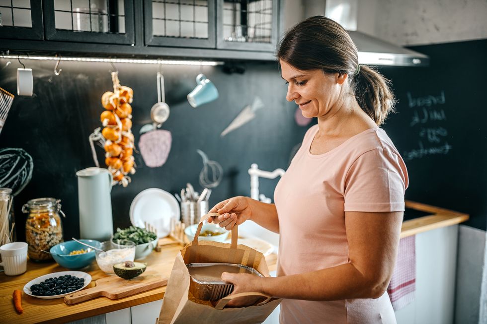 woman packing lunch box at kitchen